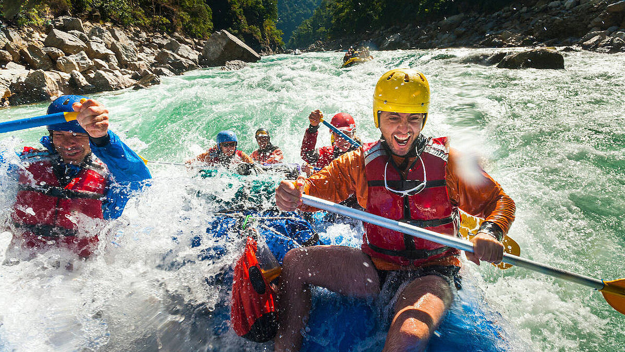 Männer in Booten beim River Rafting