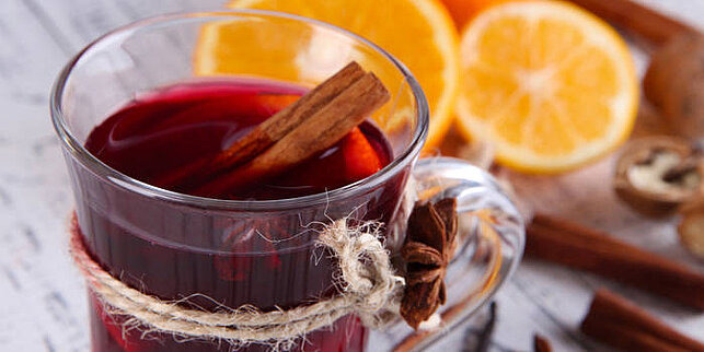 Alkoholfreier Glühwein Ein Glas Glühwein mit Zimtstange und Orangenscheiben