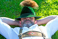 Mann mit Jägerhut liegt auf einer Wiese