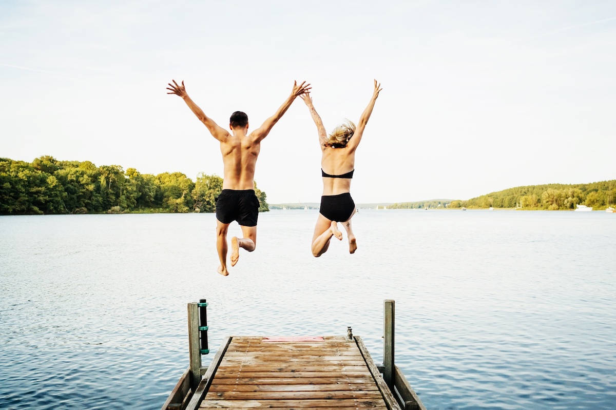 Ein Mann und eine Frau springen in einen See